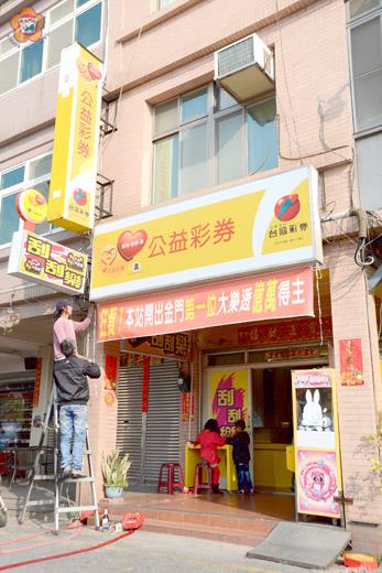 財神到訪金門來！金門地區首度開出大樂透頭獎，店家在昨天早上急忙製作紅布條張貼在店面前，提醒買家店中開出大樂透，許多民眾更是趁著彩券行運勢正旺，加碼購入各式樂透彩券。（董森堡攝）