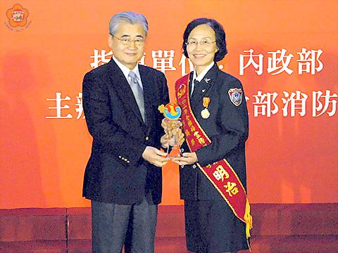 烈嶼婦宣分隊分隊長吳明治榮獲內政部消防署102年「鳳凰獎」婦宣楷模，由行政院副院長毛治國頒發獎章肯定。
（消防局提供）