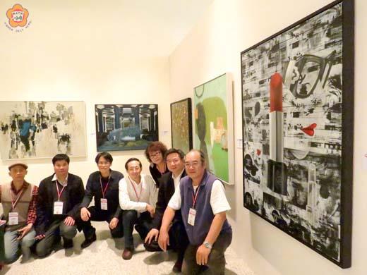 陶文岳（左四）、江宇（左五）、林金標（右二）、徐明豐（左二）、連建興（左一）、周沛榕（左三）等人在第28屆亞洲美展合影，圖最右邊為江宇的作品〈欲望清單〉。（張建騰攝）