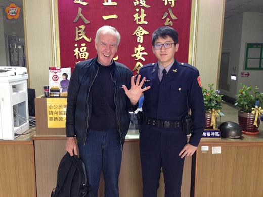 來自英國的馬爾柯特到金門旅遊途中不慎遺失心愛的畫冊及護照等重要證件，在金城派出所員警的熱心協助下，終於尋回遺失珍藏畫冊及護照等重要證件，他高興的出示來金的寫生畫作，還開心的與熱忱協尋的員警辛益昌合照。
（金城警分局提供）