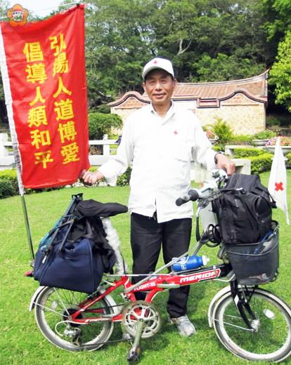   「獻血大王」高永華於清明節前騎著鐵馬來到金門榕園，車後插的旗幟上寫著：「弘揚人道博愛；倡導人類和平」。（張建騰攝）