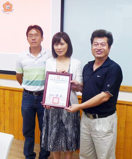   金大管理學院董燊院長致贈感謝牌予國家地理頻道李敏副總經理。
（金門大學提供）