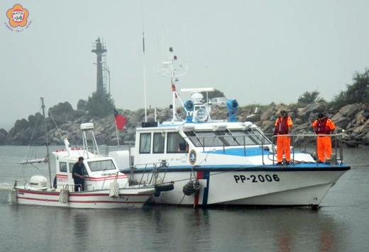 海巡艇把失去動力的「金鑫8號」（左）小型客貨船拖帶進入新湖漁港。
（第十二巡防區提供）