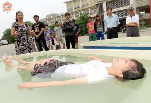 金門農工以「金門pi的奇幻漂浮」為主題打造了快活的微型「死海」；女教師林鈺卿「下海」親身感受之後，覺得很有趣；校長劉湘金（後左一）很肯定養殖科一系列的海洋教育活動。（張建騰攝）