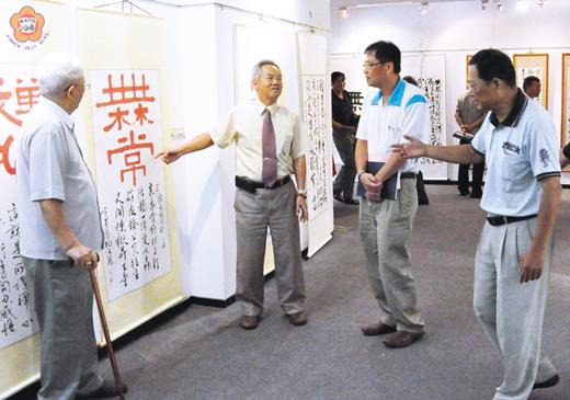   「青山不老」書法展暨長青樹石藝術展昨開幕：書法展出者引導與會貴賓參觀作品。（陳麗妤攝）