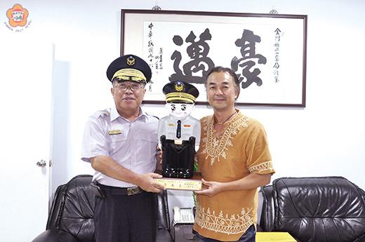 　縣籍陶藝家王明宗（右）出借藝術品美化警察局藝術走廊展覽，縣警局長謝榮隆（左）特致贈陶瓷警察寶寶表示感謝。（莊煥寧攝）
