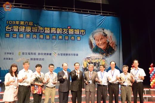   稅務局以『飛躍稅務通-跨縣市辦稅嘛ㄟ通』專案海報，榮獲「台灣健康城市暨高齡友善城市-健康城市組」口頭海報優勝獎，圖為稅務局、縣府與獲獎單位同台領獎。（稅務局提供）
