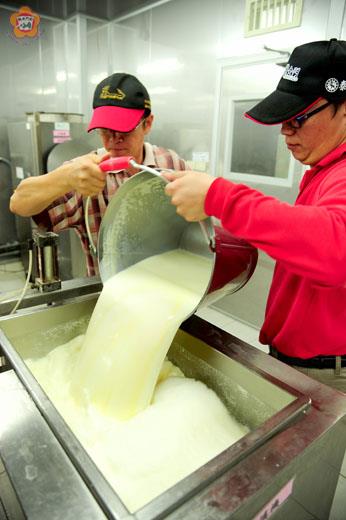 　畜試所青草地鮮奶熱銷，員工們在工廠內忙著搬動現擠的鮮奶。（董森堡攝）
