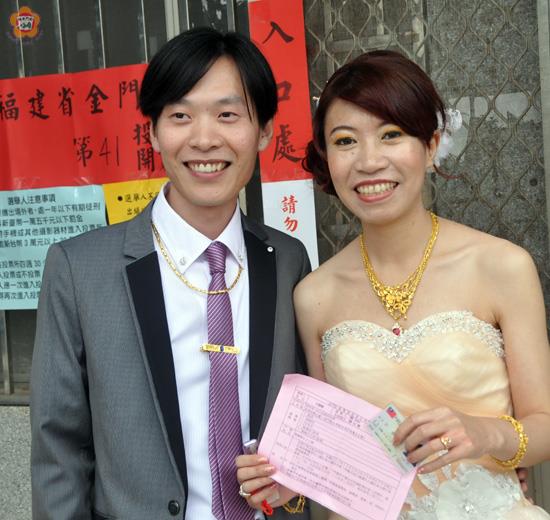   在「百年好合」的婚姻入口處，新娘王碧婷百忙之中，仍抽空由新郎楊凱智送她走進九合一（五合一）投開票所的入口處。
（張建騰攝）