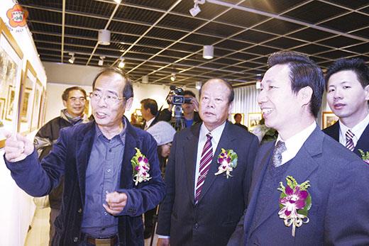   「洪清漳-與海有約」攝影展，昨元旦於烈嶼鄉文化館展出：作者洪清漳（左）向縣長陳福海（右）、烈嶼鄉長洪成發（中）等來賓介紹作品。（許加泰攝）