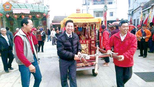   湖下、安岐、湖尾三鄉，供奉忠肝義膽的關聖帝君，輪值駐祀廟宇，每年農曆正月初二，三鄉熱鬧舉行迎關帝爺活動，縣長陳福海（左二）、金寧鄉長陳成勇（右）和鄉親一起護持關聖帝君的神輿，巡安地方。（縣府提供）