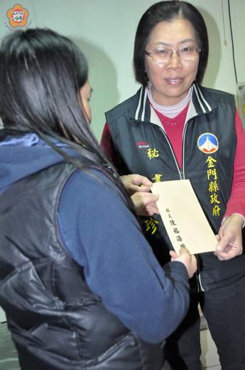   縣長機要祕書黃秀珍（右）將二十萬元濟助金交給案主的妹妹代收。
（張建騰攝） 