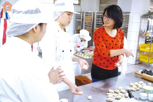   寧中小烘焙技藝課程，老師黃國娣（右）指導學員製作糕餅。（許峻魁攝）