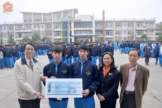 在校長劉湘金（右二）、教務主任洪亞賞（右一）及全校師生見證下，台電金門區營業處處長王仁炳（左一）把「台灣電力公司103學年度高級職業學校技術類獎學金」頒給王柏凱（左二）與薛家和（左三），兩人畢業後將被台電錄用。（張建騰攝）