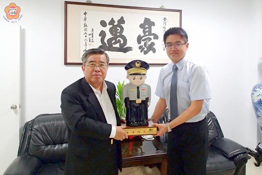   縣警局長謝榮隆贈警察寶寶予楊士擎律師，感謝他提升警察局執法素質。（莊煥寧攝）