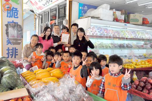   金湖國小幼兒園小綠班小朋友到學校旁的哈果青水果行遞送感謝狀給老闆（後排右二），感謝老闆日前贈送許多水果。（陳冠霖攝）