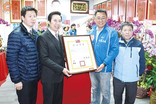 　縣長陳福海（左二）兼金門縣選委會主委在兼任縣選委會總幹事王中聖處長（左一）等人陪同，頒發立委當選證書給新科立委楊鎮浯（右二），並表達祝賀之意。（莊煥寧攝）