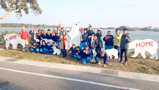 國立金門農工養殖科昨日在校長劉湘金、水產養殖科主任董倫如帶領下，號召科內同學給太湖旁的北極熊過聖誕節，師生們並一起製作聖誕帽、愛心圖樣，希望能喚醒大家重視環境議題，不要讓北極熊沒有下雪的聖誕節可以過！（金門農工提供）