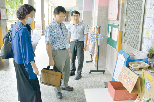 賢庵國小校長楊肅健陪同認證委員在校園進行實地審查。(賢庵國小提供)