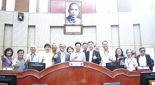 金門縣議會議長洪允典(中)與來訪全國工商建研會參訪團在議事廳主席台合影。(議會提供)