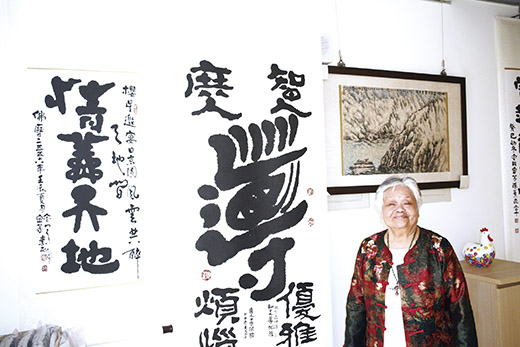 金門縣第四屆文化獎得主書畫家陳素民與她的書畫作品。（楊水詠攝）