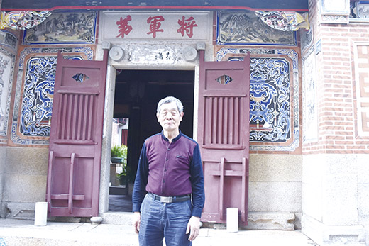 傳統建築土木匠師沈富春在親手修復的「將軍第」前留影。(莊煥寧攝)
