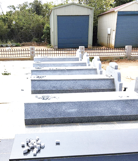 金沙鎮公所在金門縣殯葬管理所、金沙鎮公墓管理員協助下，於金沙公墓內各個墓地提供小石塊，方便鄉親「掛墓紙」使用。（金沙鎮公所提供）