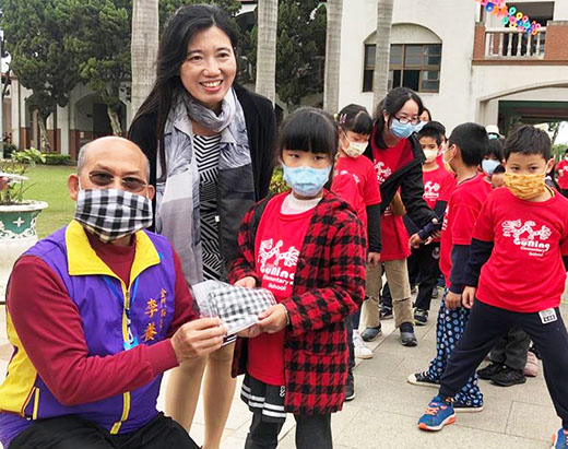 議員李養生將社區婆婆媽媽們精心製作的三百個「兒童花帔口罩套」贈與古寧國小師生。(古寧頭社區提供)