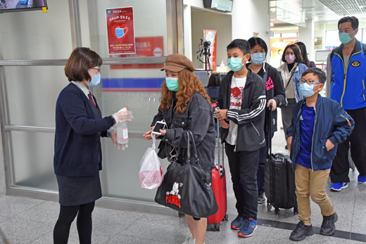 聖祖食品自2日起至10日每天送出口罩300個，入境旅客也噴灑酒精消毒。（李金鎗攝）