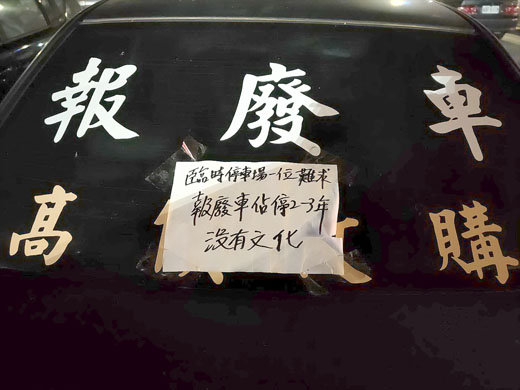 「高價收購報廢車」的車輛長時間佔據停車位,民眾在該車上貼上怒罵的言詞。
(金城分局提供)