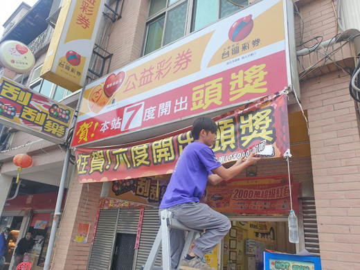 店家一早更換紅布條。(許峻魁攝)