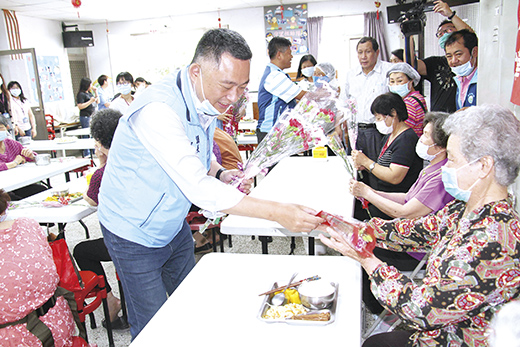 楊鎮浯縣長探訪盤山社區照顧關懷據點，贈送長者康乃馨，提前祝賀母親節快樂。（李金鎗攝）