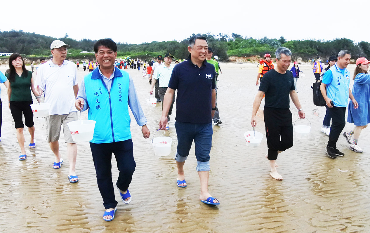 縣長與貴賓們流放魚苗,藉以友善、保育、永續金門海域生態。(陳麗妤攝)