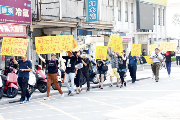 金門縣公道正義協會榮譽理事長張馨尹率眾走上街頭抗議司法不公,希望相關單位能伸張正義、以保障權益。(莊煥寧攝)