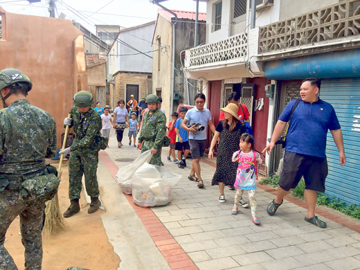 颱風警報解除後，金防部戰車營投入協助環境清潔工作，抵金的遊客見狀，也連聲向國軍致謝。（陳麗妤攝）