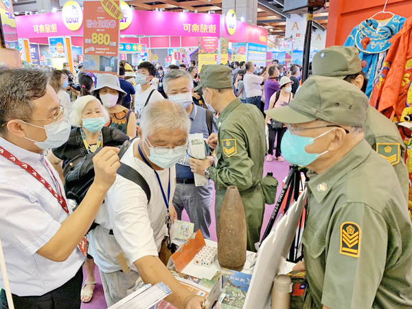 著草綠服的正港金門老兵志工協助宣傳金門老兵召集令活動,格外引人注目。(縣府提供)