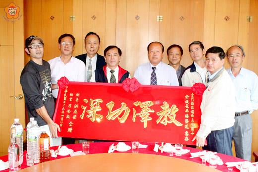 上岐國小代校長余平禧(左四)自杏壇退休,烈嶼鄉長洪成發(右五)和公所秘書呂合成(左三)致贈大紅彩匾祝福。(楊水詠攝)