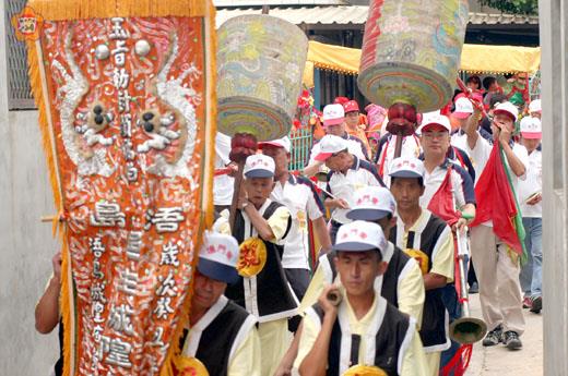 浯島城隍繞境,「遷治紀念旗」走在香陣的最前頭,還有了亞、托燈,告知香陣隊伍來了。(民俗學者許維民提供)
