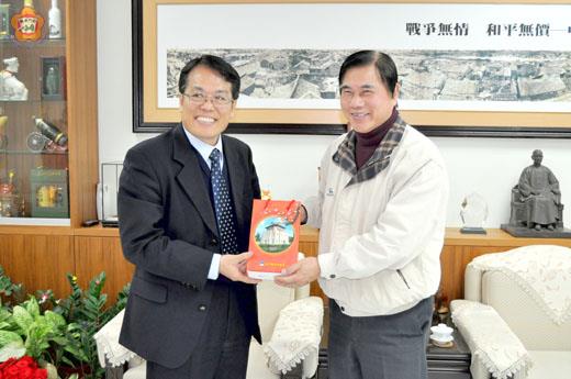 縣府主任秘書盧志輝昨接見台北市政府工務局長李咸亨,致贈紀念金酒表歡迎。(楊水詠攝)