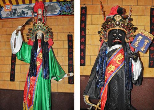 左、謝將軍頭戴錐形方帽,右手持扇,左手拿令牌,有「白無常」之稱;右、范將軍臉龐黧黑,手舉「賞善罰惡」警示牌,有「黑無常」之稱。(楊水詠攝)