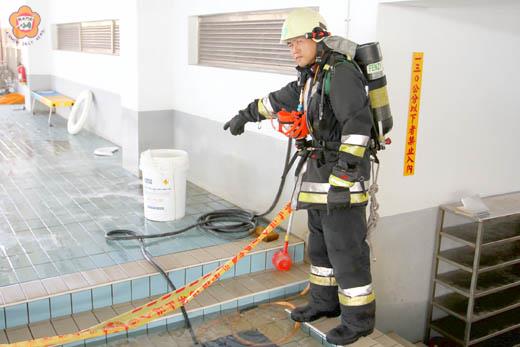 縣立游泳池昨日上午發生氯粉桶爆炸,造成泳池徐姓救生員臉部受傷,及一名國三男學生背部紅腫送醫,消防人員手指的就是爆裂傷人的氯粉桶。(莊煥寧攝)