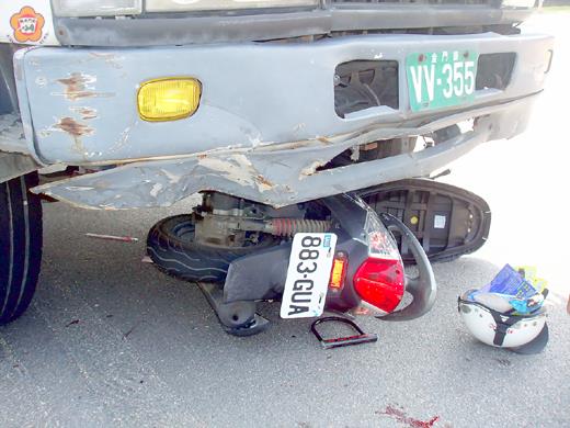 金寧鄉桃園路與環島南路三段路口發生大貨車與機車相撞車禍，左轉的機車被直行的大貨車拖行了十幾公尺，謝姓機車騎士傷重送醫急救。（莊煥寧攝）