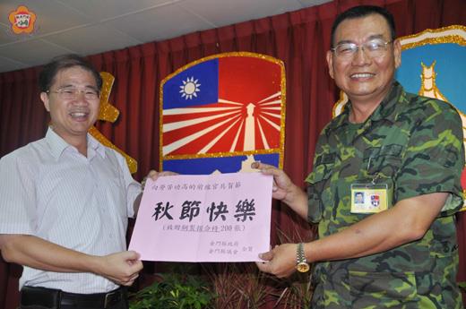   王世塗（右）由李沃士（左）手中接過中秋禮單並回贈感謝狀；他說：金門人保衛金門將是趨勢。（張建騰攝）