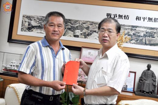 金城鎮西門里許燕騰獲選為敬老楷模將赴台接受表揚,縣長李沃士(右)致贈程儀祝賀。(李金鎗攝)