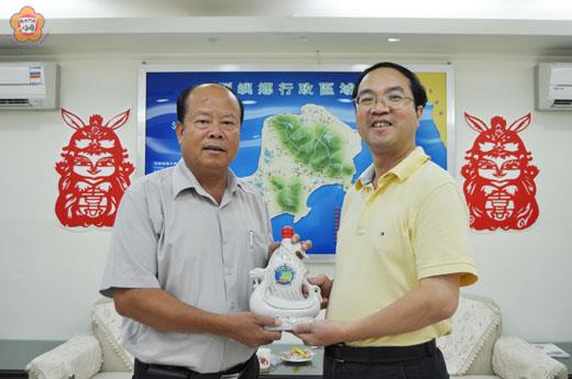   大陸福建省旅遊協會金馬澎踩線團由福建省旅遊局副局長陳揚標率領前往烈嶼鄉公所拜會，鄉長洪成發致贈「一帆風順」造型紀念酒歡迎。（李金鎗攝）