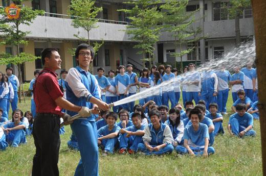   金湖消防分隊小隊長陳梓和指導學生使用消防栓中的水帶及瞄子。（張建騰攝）