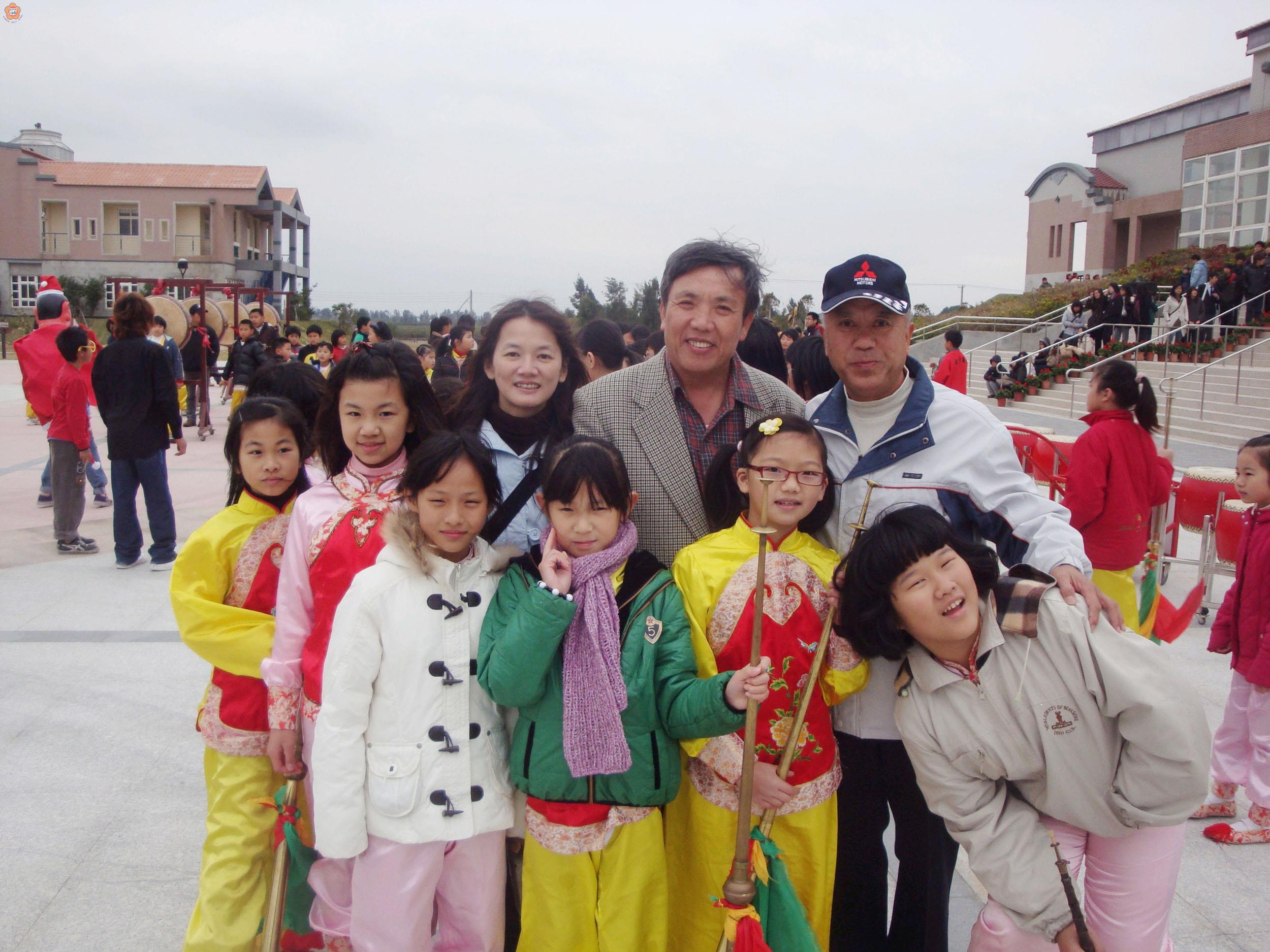 樂團幕後推手李麗娟老師(後排左三)、與現任校長張樾(後排右二)、創團校長楊肅正(後排右一)和子弟兵在文化園區演出後合影。(中正國小提供)