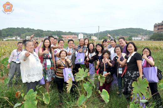 烈嶼鄉長洪成發陪同民宿業者下田體驗芋田的田園風光,贈送新鮮芋頭,業者樂透,豎起大拇指稱讚烈嶼芋「尚讚」。(許加泰攝)