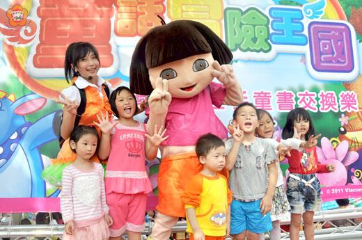 中華民國兒童教育關懷協會與音象文教事業共同辦理的「童話冒險王國」活動,卡通主角Dora和QQ姊姊現身於舞台,小朋友爭相合照。(許加泰攝)
