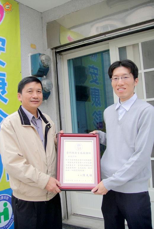   金門縣衛生局長陳天順（左）昨贈感謝狀給醫師吳英傑（右），感謝到烈嶼鄉開設診所，提供鄉民日間門診及夜間急診醫療服務。（金門衛生局提供）